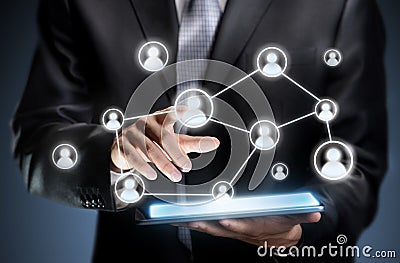 Businessman pressing people icons on a tablet Stock Photo