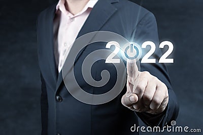 Businessman pressing 2022 start up business. Press the start button. 2022 new year concept. business man try to start up new year Stock Photo