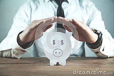 Businessman protect paper piggy bank. Saving money concept Stock Photo