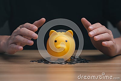 businessman protecting money with a piggy bank on the desk, financial stability management concept. Stock Photo