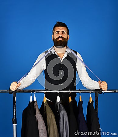 Businessman with proud face near jackets on blue background. Stock Photo