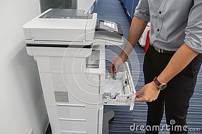 Businessman pull multi function office printer tray to put paper for printing documents Stock Photo