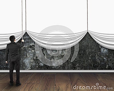 Businessman pull open blank white curtain covered dirty concrete Stock Photo