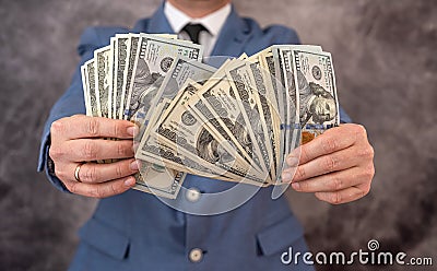 Businessman puts dollar banknote money in the pocket of his exquisite expensive suit. Stock Photo
