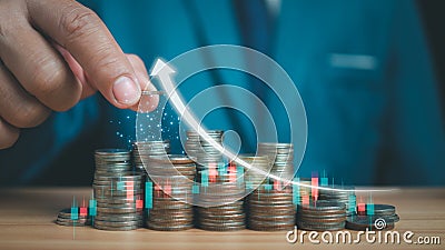 Businessman puts money on pile of coins. Ideas for investing and growing a business, maximizing profits from business, ideas for Stock Photo