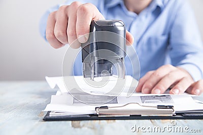 Businessman puts a stamp on the documents in the office Stock Photo