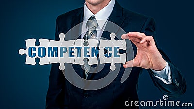The businessman puts on the virtual puzzles word competence. The business concept. Stock Photo