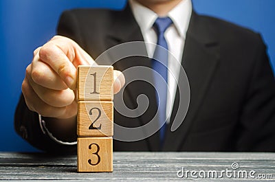 Businessman puts wooden blocks with the number 1 2 3. Task list. Alternate items and conditions for implementation. Contract road Stock Photo