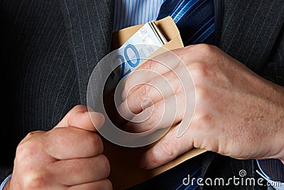 Businessman Putting Envelope Of Euros Into Jacket Pocket Stock Photo