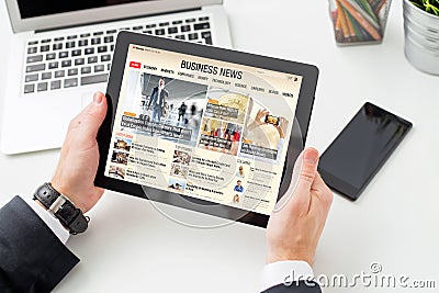 Businessman reading business news on tablet. All contents are made up. Stock Photo