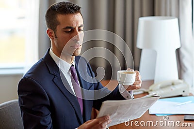 Businessman reading newspaper and drinking coffee Stock Photo