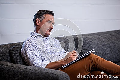 Businessman reflecting with his notepad Stock Photo