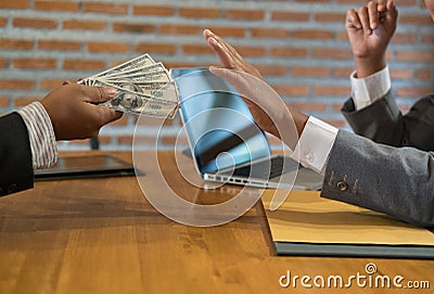 Businessman rejecting money cash banknote from a man. honest business people in suit refuse to take the bribe - anti bribery, cor Stock Photo