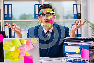 The businessman with reminder notes in multitasking concept Stock Photo