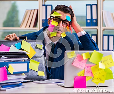 The businessman with reminder notes in multitasking concept Stock Photo