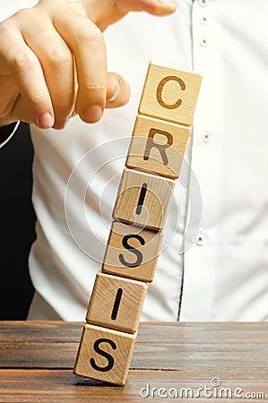 Businessman removes wooden blocks with the word Crisis. The exit from the crisis and financial stability. Focus on resolving the Stock Photo