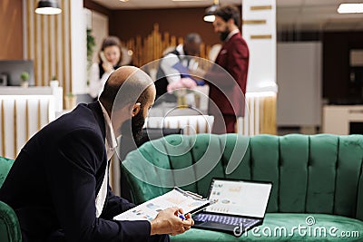 Businessman review documents in lobby Stock Photo