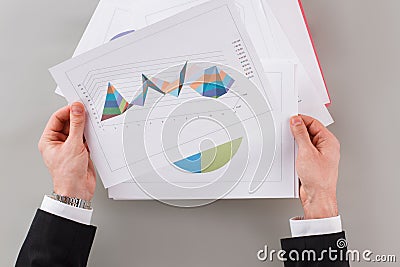 Businessman reviewing data in financial charts and graphs. Stock Photo