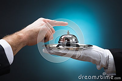 Businessman Ringing In Service Bell Held By Bellboy Stock Photo