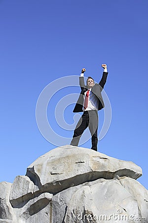 Businessman on rock Stock Photo