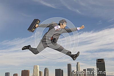 Businessman Running Midair Above City Stock Photo