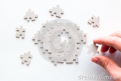 Businessman`s hand assembling pieces of a puzzle Stock Photo