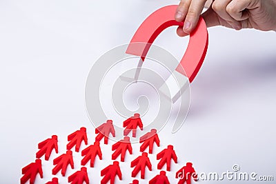 Businessman Attracting Red Team With Horseshoe Magnet Stock Photo