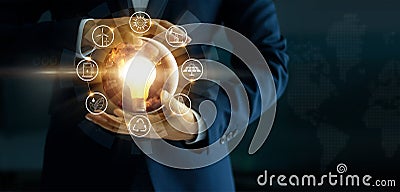 Businessman holding glowing light bulb with energy sources icon Stock Photo