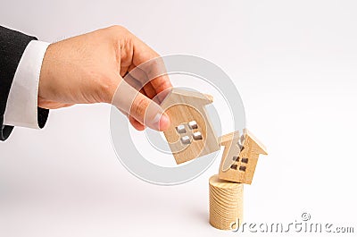 The businessman`s hand replaces the old broken house with a new one. concept of renovation, renovation of housing and demolition Stock Photo