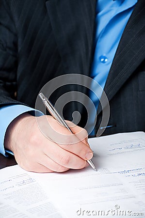 Businessman`s hand signing contract Stock Photo