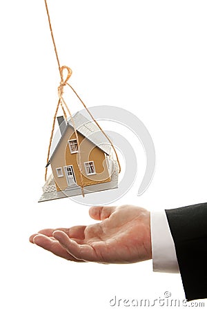 Businessman's Hand Under Dangling House Stock Photo