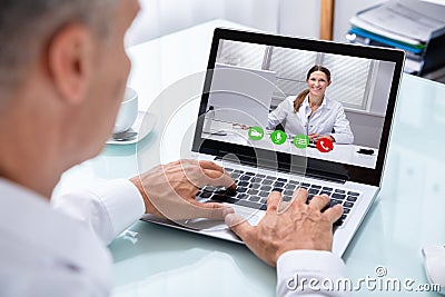 Businessman Videoconferencing With Doctor On Laptop Stock Photo