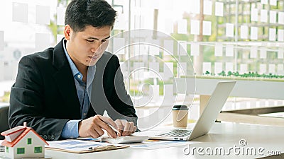 Businessman`s hands calculate interest, taxes and profits to invest in real estate and home purchase real estate agent at office j Stock Photo