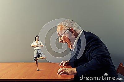 Businessman screaming at smiley woman Stock Photo