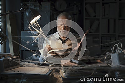 Businessman searching for paperwork in an abandoned office Stock Photo