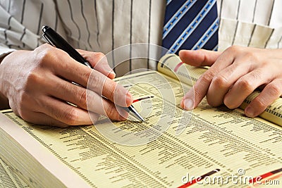 Businessman searching in yellow pages Stock Photo