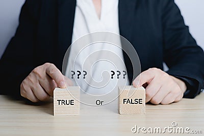 businessman is selecting a block that has the word true or false on it. deciding Think with true or false options. Stock Photo