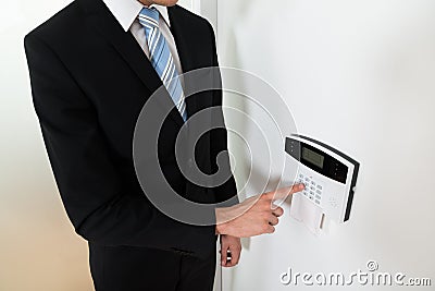 Businessman Setting Home Security Alarm System Stock Photo