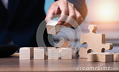 The businessman setting up a wooden cube with space for writing letters to plan the work, business concept. Stock Photo