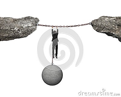 Businessman shackled by ball hanging on iron chains link cliffs Stock Photo