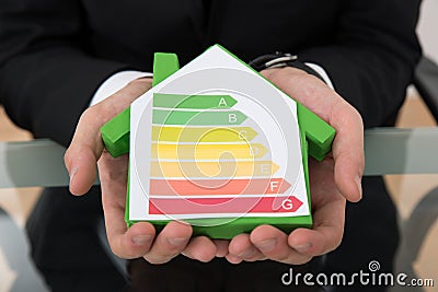 Businessman showing energy efficient chart on house model Stock Photo