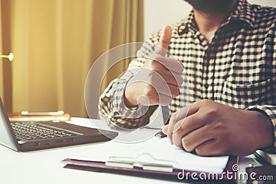 Businessman showing thumbs up in his workplace.Tump up concept Stock Photo