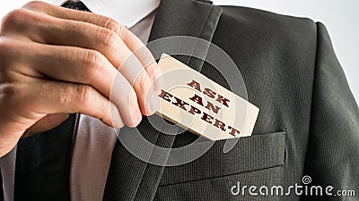 Businessman showing a wooden card reading Ask an expert Stock Photo