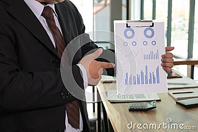 Businessman shows analytic financial accounting market chart and Stock Photo