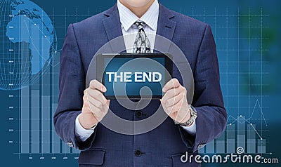 Businessman shows tablet with the inscription the end. Stock Photo