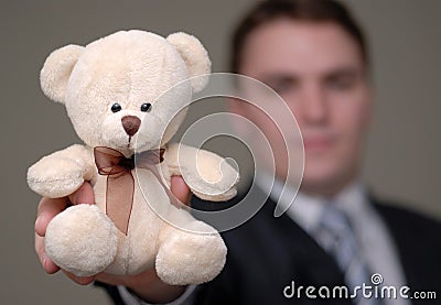 Businessman Shows Teddy Bear with Shallow Depth of Field Stock Photo