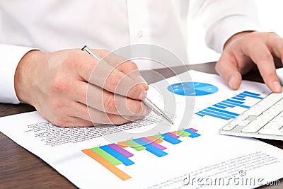 Businessman signs a document at the desk in the office Stock Photo