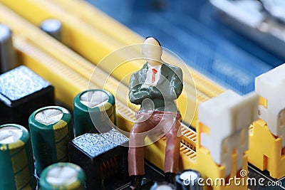 Businessman sit on a computer motherboard. Stock Photo