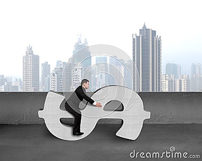 Businessman sitting on concrete money symbol Stock Photo