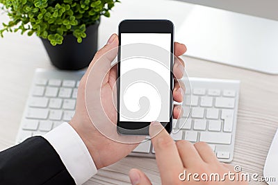Businessman sitting at desk and holding phone with scre Stock Photo